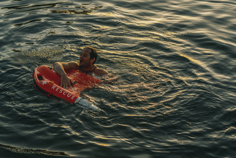 troubled swimmer holds on a remote control lifebuoy