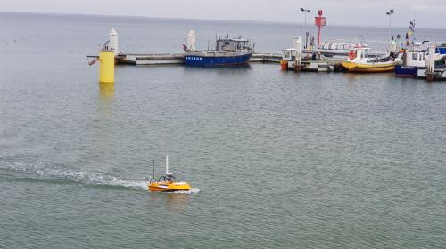 SL20 small unmanned surface vehicle sailing near a dock