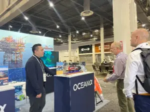OceanAlpha team discussing autonomous USV technology with visitors at OTC 2026